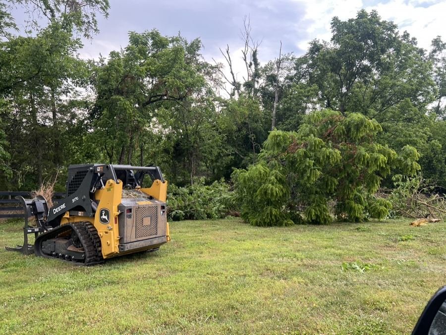John Deere 317G with grapple attachment clearing cut brush
