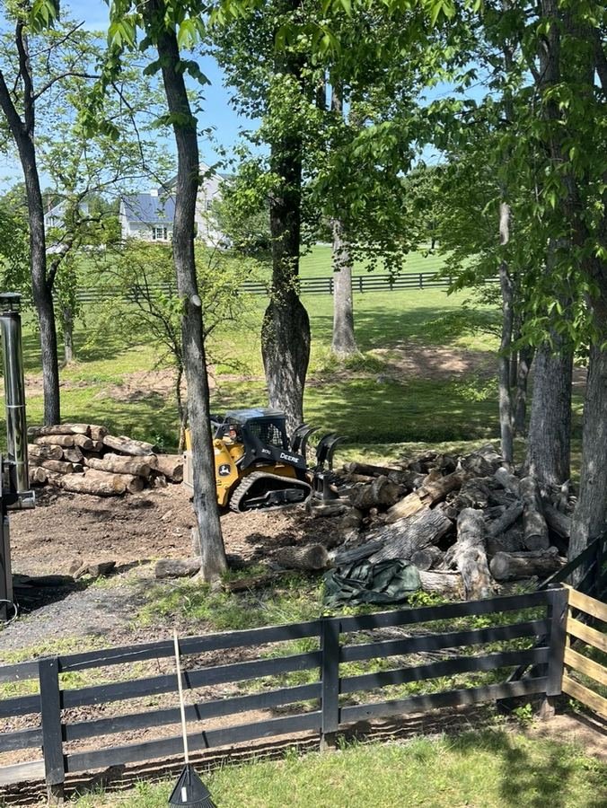 John Deere 317G with grapple attachment handling log piles